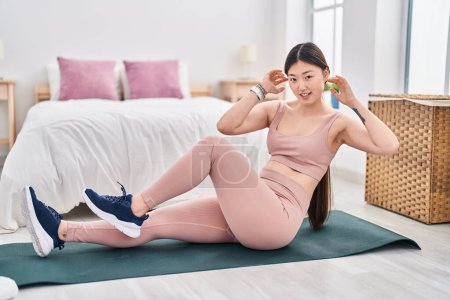 Photo for Chinese woman smiling confident training abs exercise at bedroom - Royalty Free Image