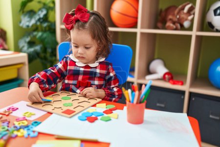 Photo for Adorable blonde toddler playing with maths puzzle game sitting on floor at kindergarten - Royalty Free Image