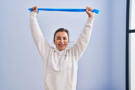 Photo for Middle age woman smiling confident training using elastic band at sport center - Royalty Free Image