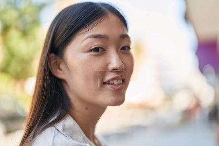 Téléchargez les photos : Femme chinoise souriant confiant debout dans la rue - en image libre de droit