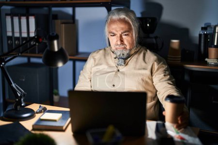 Photo for Middle age man with grey hair working at the office at night skeptic and nervous, frowning upset because of problem. negative person. - Royalty Free Image