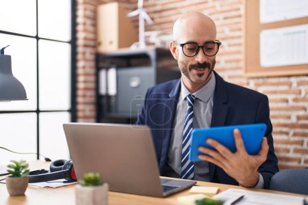 Photo for Young hispanic man business worker using laptop and touchpad at office - Royalty Free Image