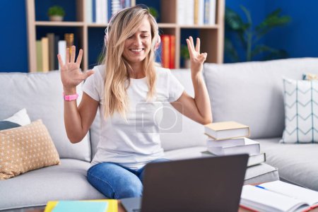 Photo for Young blonde woman studying using computer laptop at home showing and pointing up with fingers number eight while smiling confident and happy. - Royalty Free Image
