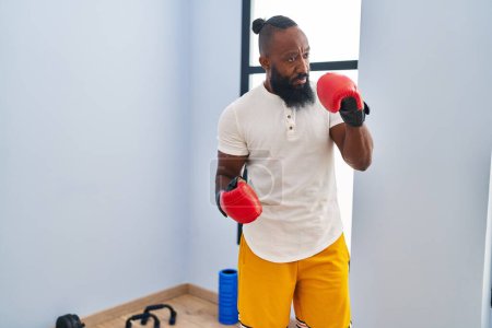 Photo for Young african american man with serious expression boxing at sport center - Royalty Free Image