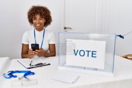 Foto de Young african american woman smiling confident using smartphone at electoral college - Imagen libre de derechos