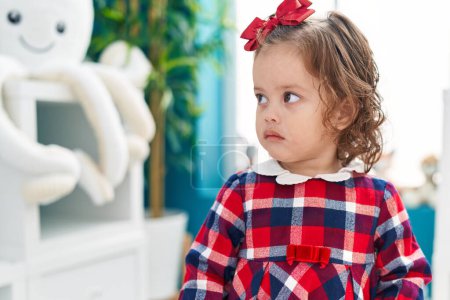 Foto de Adorable rubio niño de pie con expresión seria en el jardín de infantes - Imagen libre de derechos
