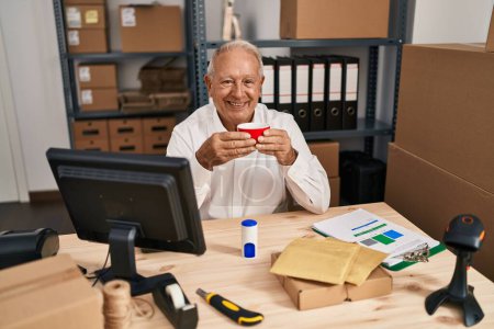 Téléchargez les photos : Senior man ecommerce business worker drinking coffee at office - en image libre de droit