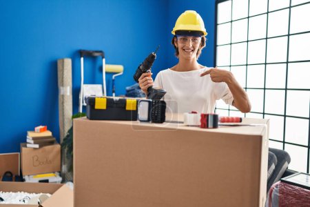 Photo for Brunette woman holding screwdriver at new home pointing finger to one self smiling happy and proud - Royalty Free Image