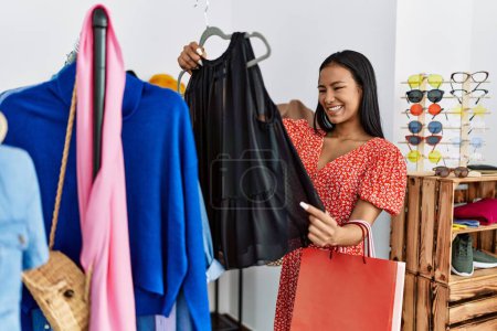 Photo for Young latin woman smiling confident shopping at clothing store - Royalty Free Image