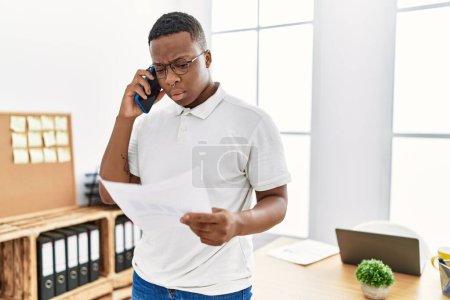 Téléchargez les photos : Young african man working speaking on the phone at business office - en image libre de droit