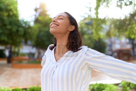 Photo for Young african american woman breathing with closed eyes at park - Royalty Free Image