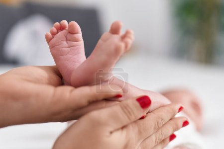 Photo for Adorable caucasian baby lying on bed having legs massage at bedroom - Royalty Free Image