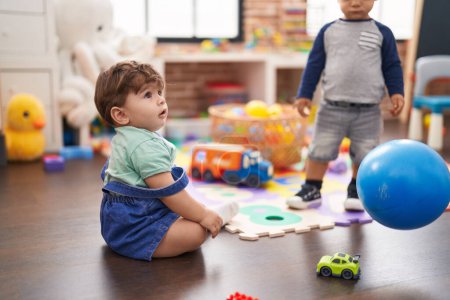 Foto de Dos niños jugando con la pelota de pie en el jardín de infantes - Imagen libre de derechos