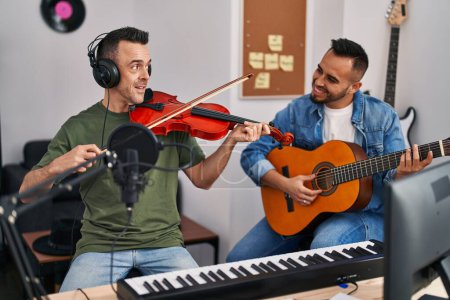Photo for Two men musicians playing classical guitar and violin at music studio - Royalty Free Image