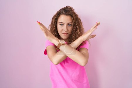 Téléchargez les photos : Jeune femme caucasienne debout sur fond rose expression de rejet croisant les bras faisant signe négatif, visage en colère - en image libre de droit