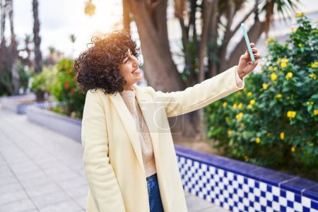 Foto de Young middle east woman excutive smiling confident make selfie by smartphone at park - Imagen libre de derechos