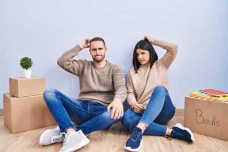 Photo for Young couple moving to a new home confuse and wondering about question. uncertain with doubt, thinking with hand on head. pensive concept. - Royalty Free Image