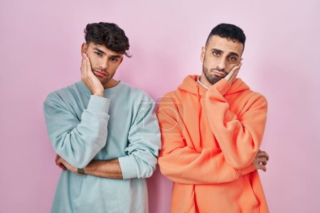 Téléchargez les photos : Young hispanic gay couple standing over pink background thinking looking tired and bored with depression problems with crossed arms. - en image libre de droit