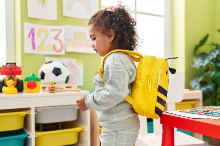 Photo for Adorable hispanic girl student wearing backpack standing at kindergarten - Royalty Free Image