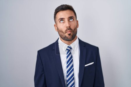 Foto de Handsome hispanic man wearing suit and tie making fish face with lips, crazy and comical gesture. funny expression. - Imagen libre de derechos