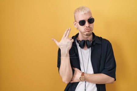 Photo for Young caucasian man wearing sunglasses standing over yellow background shooting and killing oneself pointing hand and fingers to head like gun, suicide gesture. - Royalty Free Image