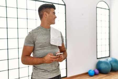 Photo for Young hispanic man smiling confident using smartphone at sport center - Royalty Free Image