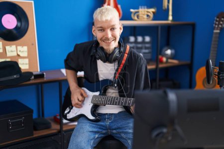 Foto de Joven hombre caucásico músico tocando la guitarra eléctrica en el estudio de música - Imagen libre de derechos