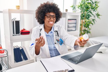 Téléchargez les photos : African american woman doctor using laptop prescribe pills at clinic - en image libre de droit