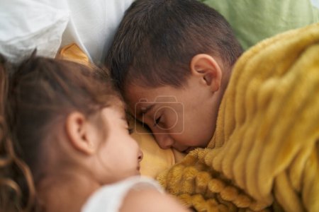 Téléchargez les photos : Frère et sœur couchés sur le lit dormant dans la chambre - en image libre de droit