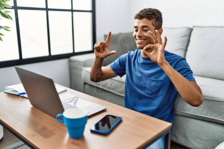 Téléchargez les photos : Jeune homme hispanique gestuelle langue des signes sur appel vidéo à la maison - en image libre de droit