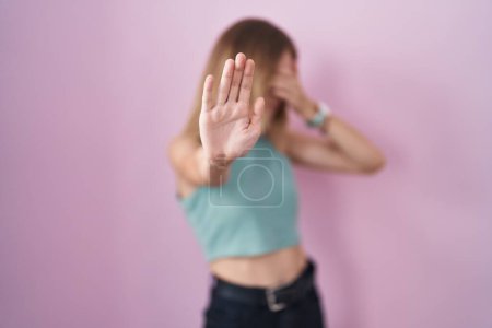 Photo for Blonde caucasian woman standing over pink background covering eyes with hands and doing stop gesture with sad and fear expression. embarrassed and negative concept. - Royalty Free Image