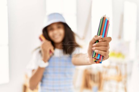 Foto de African american girl smiling confident holding colorful pencils at art school - Imagen libre de derechos