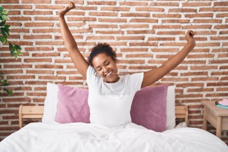 Photo for African american woman waking up stretching arms at bedroom - Royalty Free Image