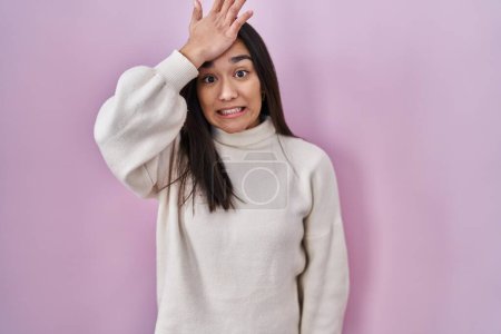 Téléchargez les photos : Young south asian woman standing over pink background surprised with hand on head for mistake, remember error. forgot, bad memory concept. - en image libre de droit