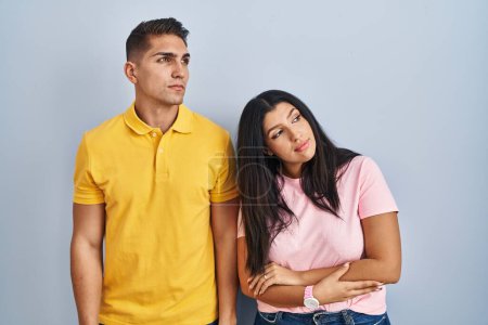 Téléchargez les photos : Jeune couple debout sur fond isolé regardant du côté avec les bras croisés convaincu et confiant - en image libre de droit