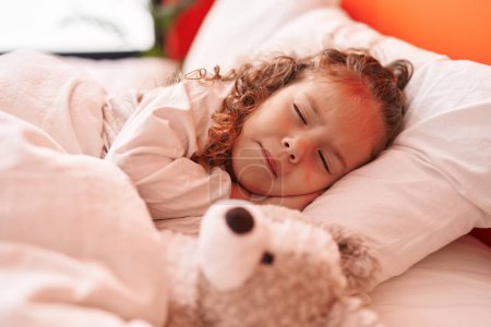 Photo for Adorable blonde toddler lying on bed sleeping with teddy bear at bedroom - Royalty Free Image