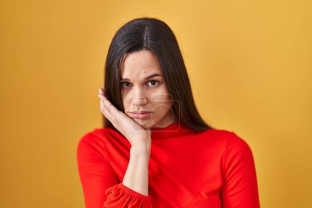 Photo for Young hispanic woman standing over yellow background thinking looking tired and bored with depression problems with crossed arms. - Royalty Free Image