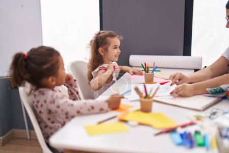 Photo for Two kids preschool students sitting on table drawing on paper at classroom - Royalty Free Image