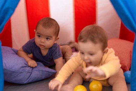 Foto de Dos niños jugando con pelotas dentro de la carpa de circo en casa - Imagen libre de derechos