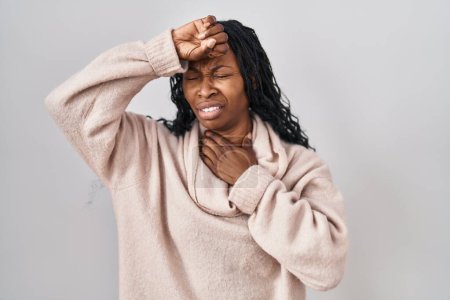 Foto de African woman standing over white background touching forehead for illness and fever, flu and cold, virus sick - Imagen libre de derechos