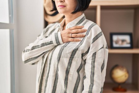 Téléchargez les photos : Jeune femme chinoise portant une bague de fiançailles avec la main sur le cœur à la maison - en image libre de droit