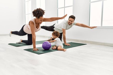 Photo for Couple and daughter smiling confident training yoga at sport center - Royalty Free Image