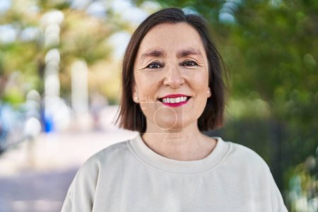 Téléchargez les photos : Femme d'âge moyen souriant confiance debout au parc - en image libre de droit