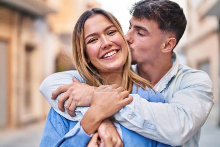 Téléchargez les photos : Jeune homme et femme couple étreignant l'autre et embrassant debout à la rue - en image libre de droit