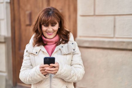 Photo for Middle age woman smiling confident using smartphone at street - Royalty Free Image