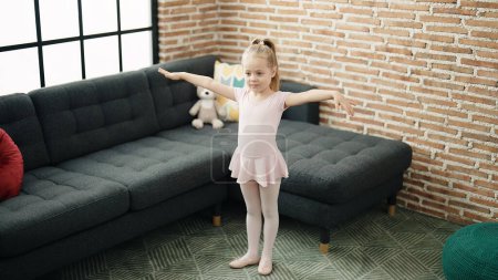 Téléchargez les photos : Adorable fille blonde ballerine souriante danse confiante à la maison - en image libre de droit