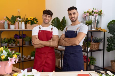 Téléchargez les photos : Two hispanic men florists smiling confident standing with arms crossed gesture at flower shop - en image libre de droit