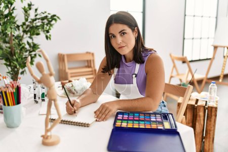 Téléchargez les photos : Jeune belle hispanique femme artiste dessin mannequin sur ordinateur portable à l'atelier d'art - en image libre de droit