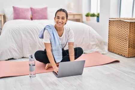 Photo for Young hispanic woman using laptop sitting on floor at bedroom - Royalty Free Image