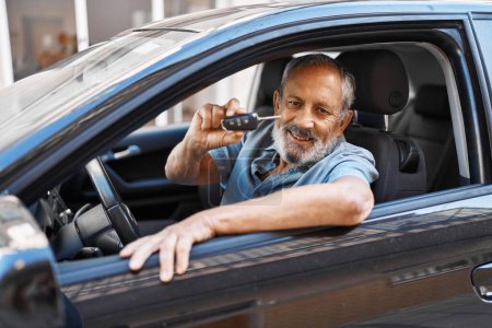 Photo for Senior grey-haired man smiling confident holding key of new car at street - Royalty Free Image